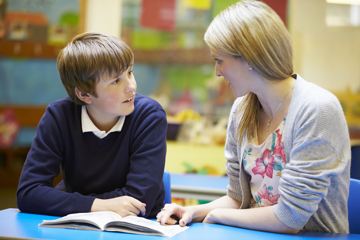 Gold _ Teacher with young male student going over a book iStock_468079587.jpg